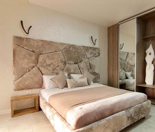 a bedroom with a large bed with a stone headboard at Four Seasons In Carpathians in Migovo