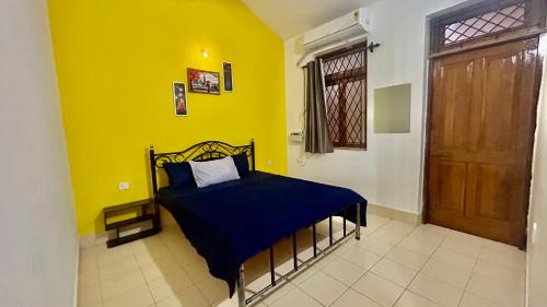 1 dormitorio con 1 cama con manta azul y puerta en Muffy’s Vacation Apartment, en Baga