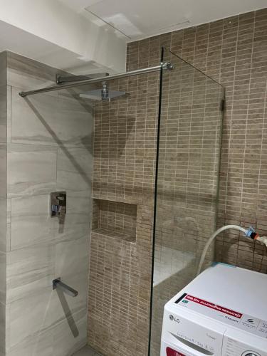 a shower with a glass door in a bathroom at Fort Victoria Loft in BGC Wifi Netflix in Manila