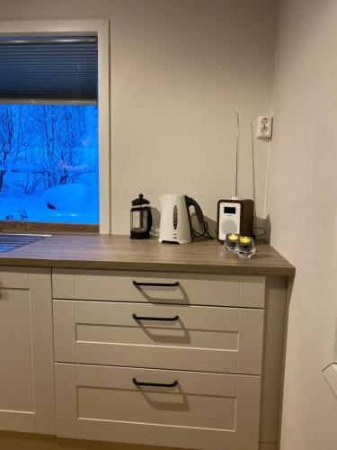 a kitchen counter with a microwave and a window at Villa Lyngenfjord in Olderdalen