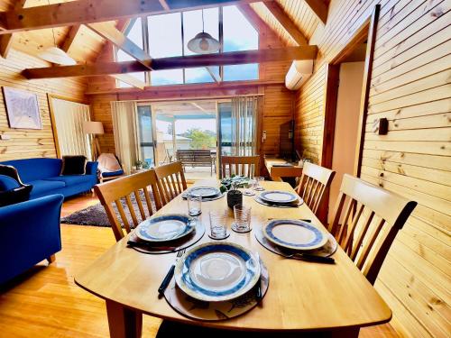 a dining room with a wooden table and chairs at House with bay views - St Helens family escape in St Helens