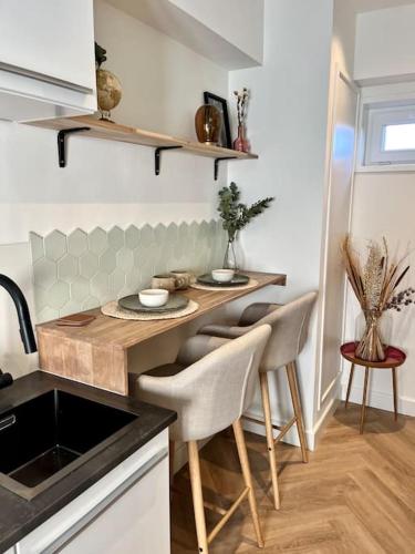 a kitchen with a counter with a table and chairs at Tiny House in center Aalsmeer I Close to Schiphol & Amsterdam in Aalsmeer