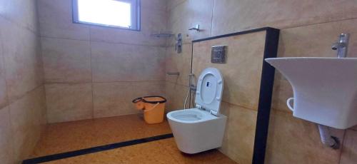 a bathroom with a toilet and a sink at Wayanad Empire Colonial Villa in Kalpetta