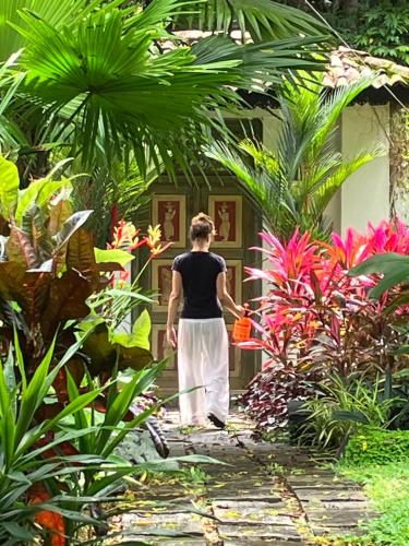 a man walking through a garden with a rake at Villa My Way Yoga Holiday in Ahangama