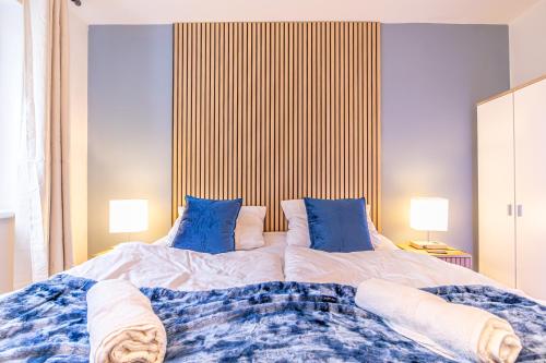 1 dormitorio con 1 cama grande con almohadas azules en 9 min to City Center via Metro 1BR 1LR with Balcony, en Viena