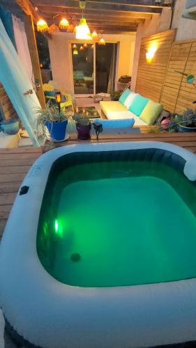 une grande baignoire verte installée dans une cour dans l'établissement appartement dans villa aquarelle, à Biguglia