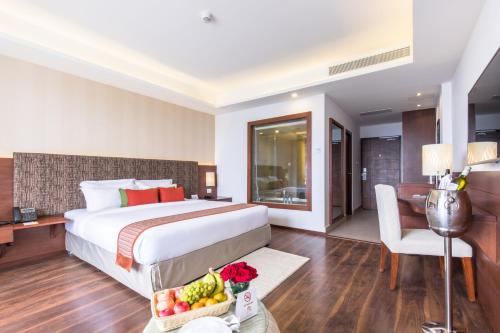 a hotel room with a bed and a table with a bowl of fruit at Mountain Glory Forest Resort in Pokhara
