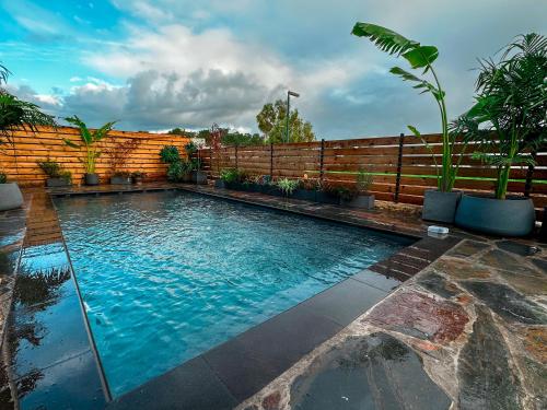 - une piscine dans un jardin avec une clôture en bois dans l'établissement Gilboa cliff eclectic villa- heated swimming pool, à Nurit