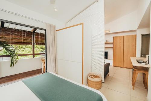 um quarto com uma cama, uma secretária e uma janela em Studio - résidence côtière luxe em Rivière Noire