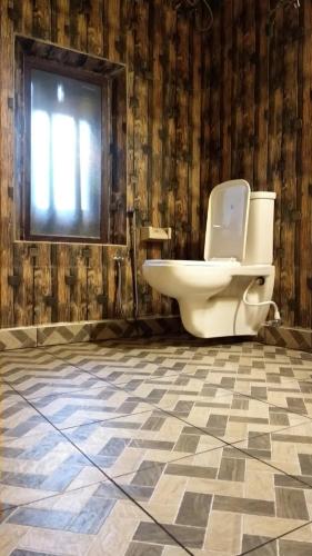 łazienka z toaletą i oknem w obiekcie New Kempty Fall Hotel w mieście Mussoorie