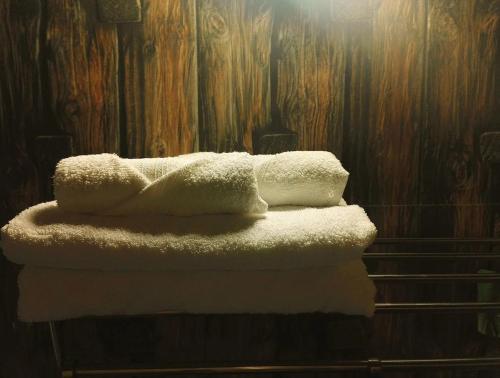 due asciugamani seduti sopra una pila di asciugamani di New Kempty Fall Hotel a Mussoorie