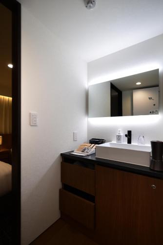 a bathroom with a sink and a mirror at ホテルプラタナス新横浜 in Yokohama
