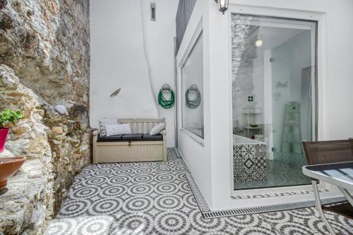 a bathroom with a walk in shower next to a glass door at Apartamento com pátio em frente praia in Paço de Arcos