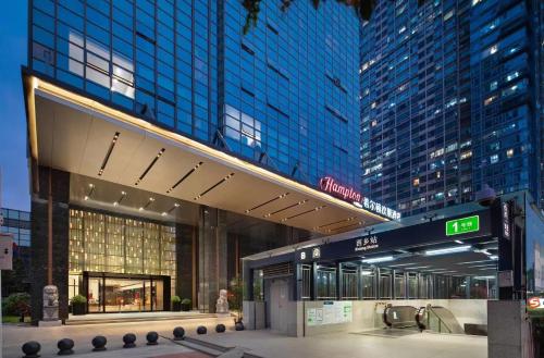 a large building with blue windows in a city at Hampton by Hilton Shenzhen Baoan Stadium in Shenzhen