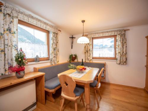 a living room with a table and chairs and a dining room at Cozy apartment in Wald im Pinzgau with balcony and barbecue area in Wald im Pinzgau