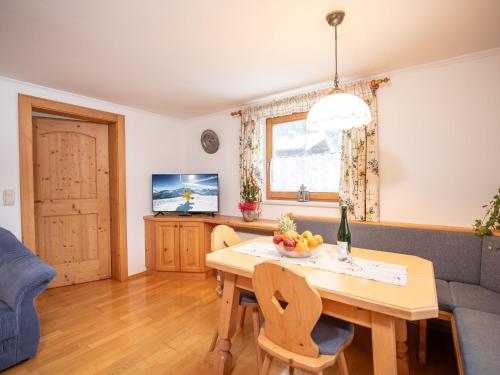 a living room with a table and a couch at Cozy apartment in Wald im Pinzgau with balcony and barbecue area in Wald im Pinzgau
