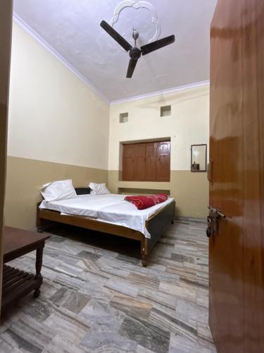 1 dormitorio con 1 cama y ventilador de techo en Satsang Lodge en Varanasi