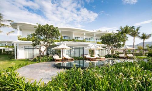 an exterior view of a resort with a pool and chairs at Cam Ranh Riviera Beach Resort & Spa in Cam Ranh
