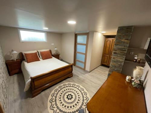 ein kleines Schlafzimmer mit einem Bett und einem Tisch in der Unterkunft Le p'tit clos de Choz (1 ou 2 chambres) in Chozeau