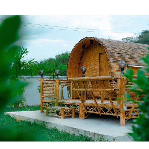 Una cabaña de madera con dos bancos delante de ella. en Quality Time Farmstay: Bamboo House, en Ban Pa Lau