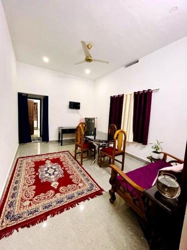 Una sala de estar con una mesa y una alfombra. en Evaa Homes, en Anachal