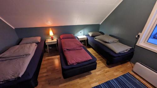 Habitación con 2 camas y mesa con lámpara. en Villa Lyngenfjord en Olderdalen