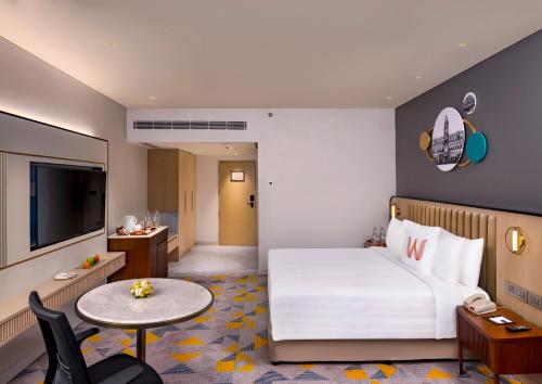 une chambre d'hôtel avec un lit et une table dans l'établissement Welcomhotel by ITC Hotels, Cathedral Road, Chennai, à Chennai