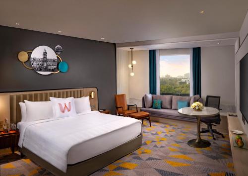 a bedroom with a bed and a living room at Welcomhotel by ITC Hotels, Cathedral Road, Chennai in Chennai