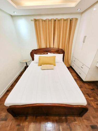 a bedroom with a large bed with a curtain at Golden Queen Suites in Baguio