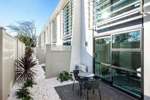 a balcony with a table and chairs in front of a building at One88 on Commerce in Whakatane