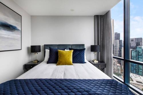 a bedroom with a large bed with a large window at The Skysill - A Sleek Inner city Sanctuary with Pool in Melbourne