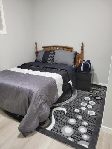 a bedroom with a large bed and a rug at Brand New 2 Bedroom Basement Suite with Wifi in Edmonton