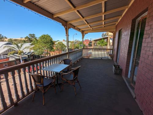 a patio with a table and chairs on a balcony at Toodyay Hotel in Toodyay