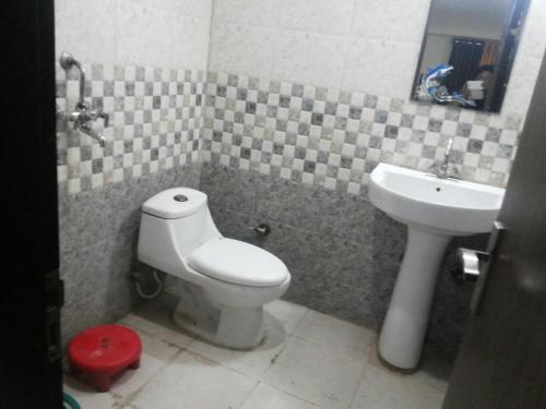 a bathroom with a toilet and a sink at Hotel Sunshine in Kāshīpur