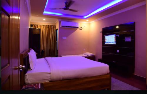 a bedroom with a bed with a purple lighting at Hotel AS Lagoon in Bhubaneshwar