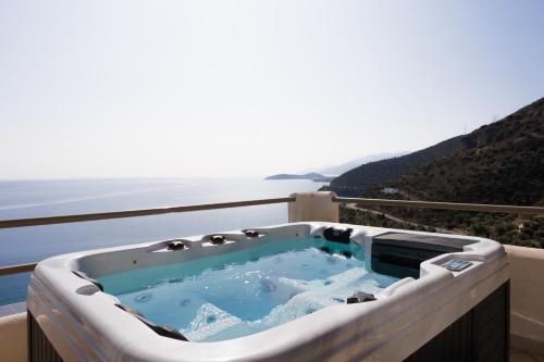 a jacuzzi tub on a balcony overlooking the water at Blue Horizon Suites in Paralion astros