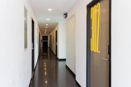 a hallway with white walls and yellow doors at M2 Hotel in Phayao