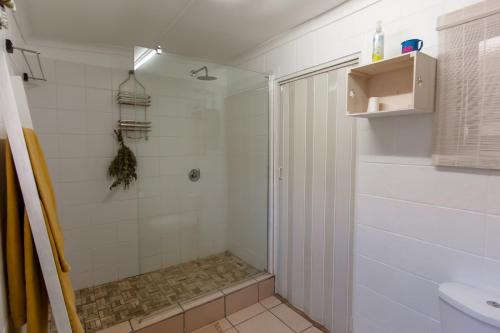 a bathroom with a shower and a sink at Surf n Sea Beachfront Holiday Home in Jeffreys Bay