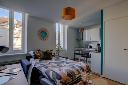 a living room with a bed and a kitchen at Le Tournassin-Balcon-Stationnement gratuit in Bourg-en-Bresse