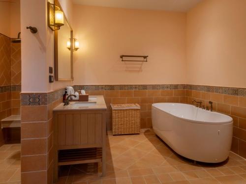 a bathroom with a large tub and a sink at Toscana Valley Hotel Portofino in Mu Si
