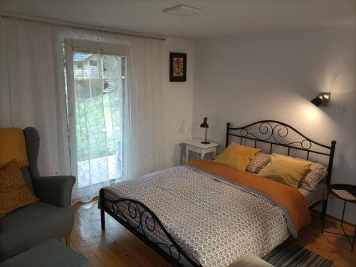 sypialnia z łóżkiem, oknem i krzesłem w obiekcie Pod Jabłonią w mieście Szczawnica