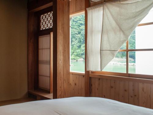 1 dormitorio con ventana y vistas al agua en RITA Izumo Sagiura, en Izumo