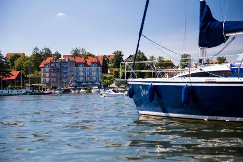 a blue boat is docked in a body of water at Ach Mazury in Mikołajki