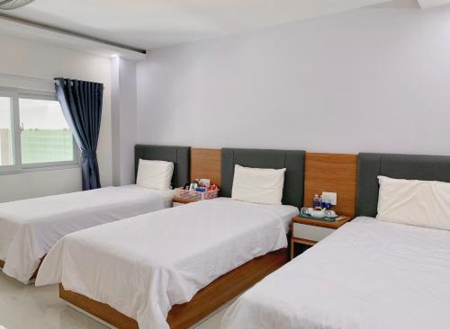 a room with two beds and a window at Thuan Phat House Soc Trang in Soc Trang