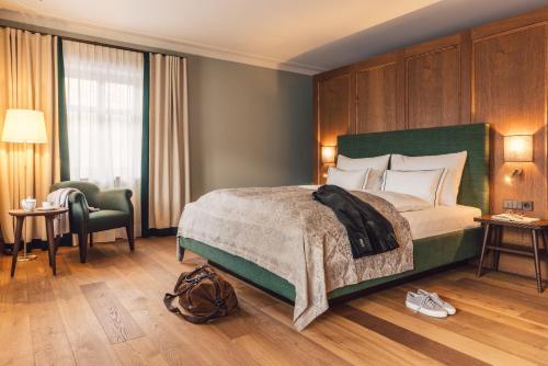 a bedroom with a large bed with a green headboard at Posthotel Taube in Schruns