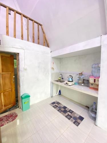 una cucina con scala e mensola con stoviglie di Alas Tegal villa cabin syariah a Wonosobo