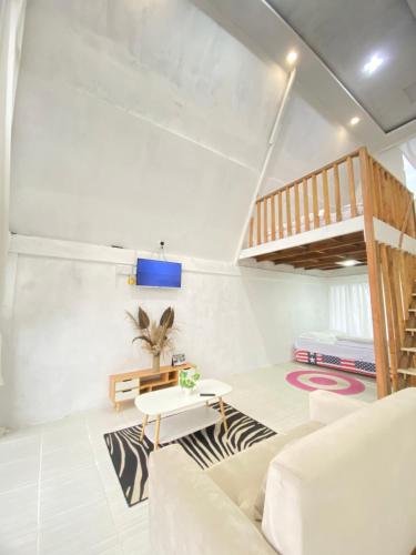 salon z łóżkiem na podwyższeniu i kanapą w obiekcie Alas Tegal villa cabin syariah w mieście Wonosobo