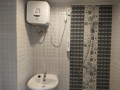 y baño con ducha y lavamanos. en Alhesa Apartment en Sunggal