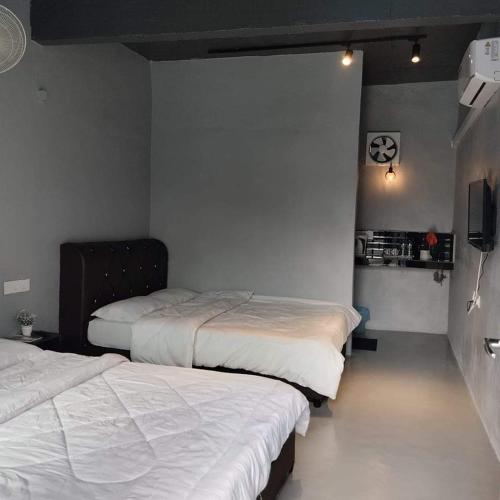 ein Schlafzimmer mit 2 Betten und einem TV. in der Unterkunft Adana Homestay & Pool in Kangar