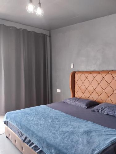 ein Schlafzimmer mit einem Bett mit einer blauen Decke in der Unterkunft Adana Homestay & Pool in Kangar